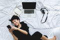 Person relaxing on a duvet while looking at their cell phone, representing a comfortable setting for scheduling a consultation with Eleven.